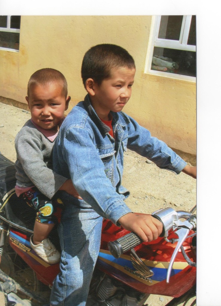 Two Afghan orphans posing on a motorbike. Bamyan 2007